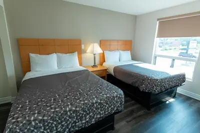 a hotel room with two beds and a window at Borden Inn and Suites in Angus