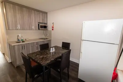 a kitchen with a table with chairs and a refrigerator at Borden Inn and Suites in Angus
