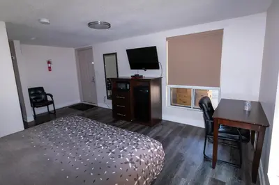 a hotel room with a bed and a desk and a television at Borden Inn and Suites in Angus