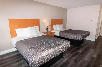 two beds in a hotel room with wooden floors at Borden Inn and Suites in Angus