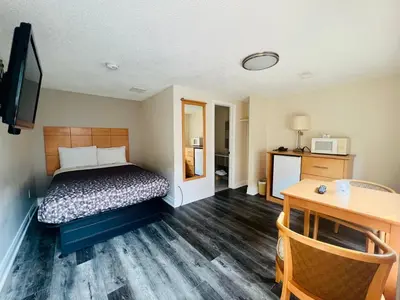 a hotel room with a bed and a desk and a tv at Borden Inn and Suites in Angus