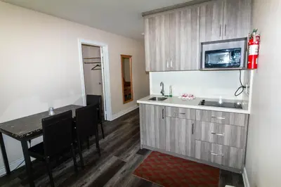 a kitchen with a sink and a table with chairs at Borden Inn and Suites in Angus