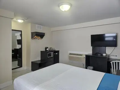 a hotel room with a bed and a tv and a room at Leelas Villa Inn Flesherton in Flesherton