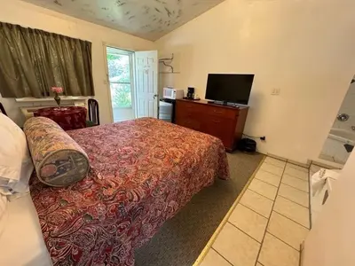 a bedroom with a bed and a flat screen tv at Holiday Motel in Orillia