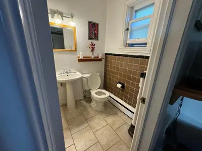 a bathroom with a toilet and a sink at Holiday Motel in Orillia