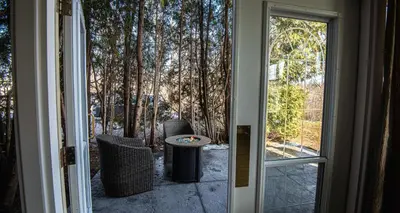 an open door to a patio with a table and chairs at Elm Hurst Inn & Spa in Ingersoll