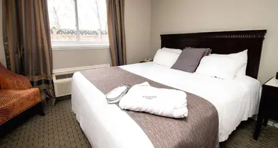 a hotel room with a bed with two towels on it at Elm Hurst Inn & Spa in Ingersoll