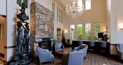 a lobby with a stone fireplace and a bar at Elm Hurst Inn & Spa in Ingersoll