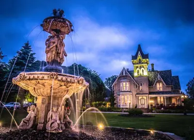 a fountain in front of a house at night at Elm Hurst Inn & Spa in Ingersoll