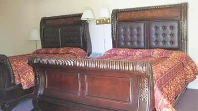two beds in a hotel room with two bedsitures at Rosecourt Motel in Stratford