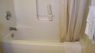 a bathroom with a tub and a shower curtain at Rosecourt Motel in Stratford