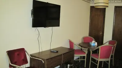 a room with a table and a television on the wall at Rosecourt Motel in Stratford