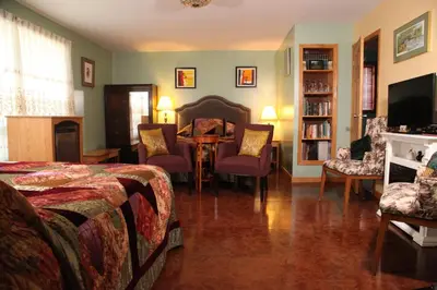 a bedroom with a bed and a table and chairs at A Garden Stroll Bed & Breakfast in Stratford