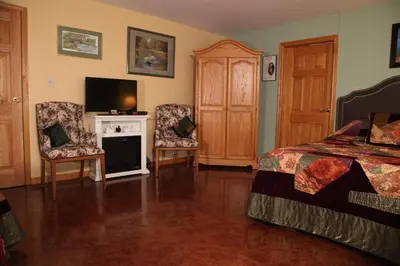 a bedroom with a bed and a fireplace and a tv at A Garden Stroll Bed & Breakfast in Stratford