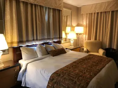 a bedroom with a large bed with white sheets and pillows at Cardinal Court Motel in Saint Thomas