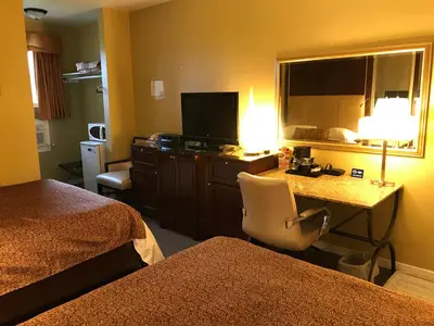 a hotel room with a desk and a television at Cardinal Court Motel in Saint Thomas