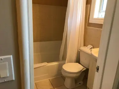a small bathroom with a toilet and a sink at Cardinal Court Motel in Saint Thomas