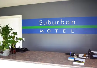 a sign for a suuburn motel on a wall at Stratford Suburban Motel in Stratford
