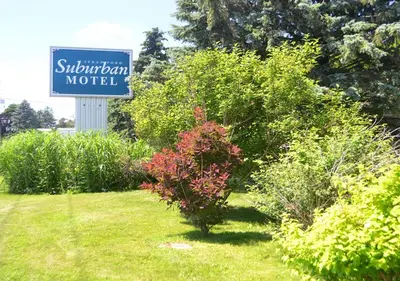 a sign for a motel next to some bushes at Stratford Suburban Motel in Stratford