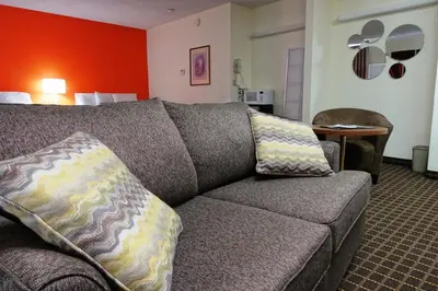 a living room with a couch in a hotel room at Howard Johnson by Wyndham Tillsonburg in Tillsonburg