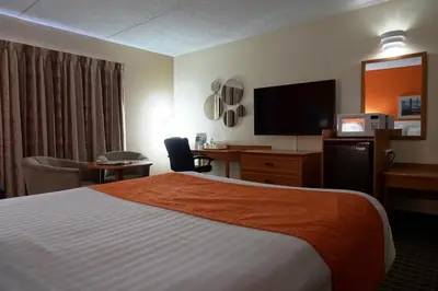 a hotel room with a bed and a flat screen tv at Howard Johnson by Wyndham Tillsonburg in Tillsonburg