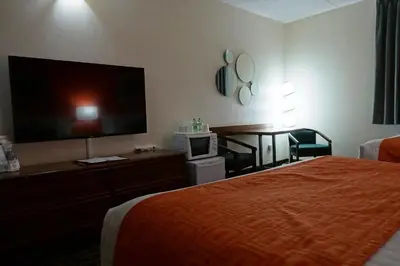 a hotel room with a bed and a flat screen tv at Howard Johnson by Wyndham Tillsonburg in Tillsonburg