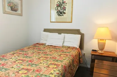 a hotel room with a bed and a lamp at Bayside Motel Trenton in Trenton