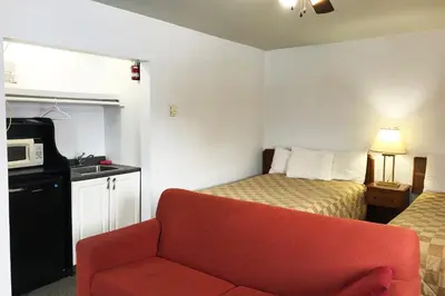 a room with a couch and a bed and a microwave at Bayside Motel Trenton in Trenton