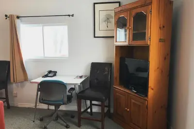 a room with a desk and a tv and a cabinet at Bayside Motel Trenton in Trenton