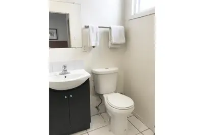 a white bathroom with a toilet and a sink at Bayside Motel Trenton in Trenton