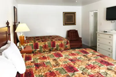 a hotel room with a bed with a quilt on it at Bayside Motel Trenton in Trenton
