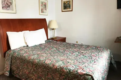 a bedroom with a bed with a colorful bedspread at Bayside Motel Trenton in Trenton