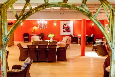 a dining room with orange walls and tables and chairs at The Ivy at Verity in Toronto