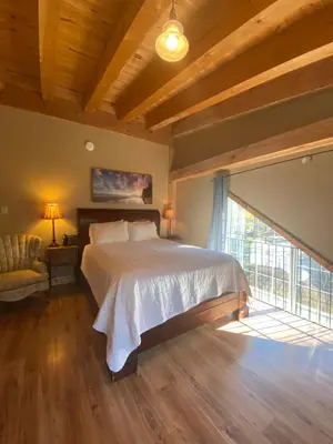 a bedroom with a bed and a large window at Timber House Resort in Brighton