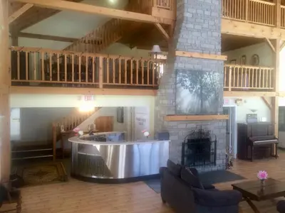 a living room with a fireplace and a staircase at Timber House Resort in Brighton