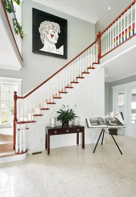 a living room with a staircase and a table at Somerset - A Private Retreat in Niagara on the Lake