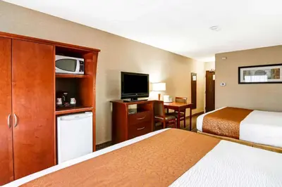 a hotel room with two beds and a flat screen tv at Quality Inn in Kitchener
