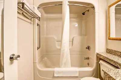 a bathroom with a shower with a white shower curtain at Quality Inn in Kitchener