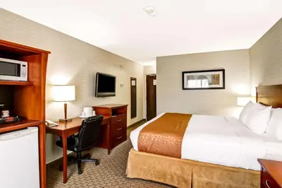 a hotel room with a bed and a desk with a computer at Quality Inn in Kitchener