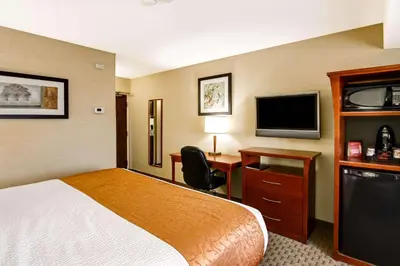 a hotel room with a bed and a desk and a television at Quality Inn in Kitchener