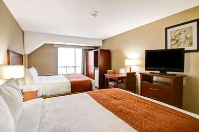 a hotel room with two beds and a flat screen tv at Quality Inn in Kitchener