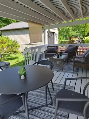 a patio with a table and chairs on a deck at Carrousel Bed & Breakfast in Cayuga