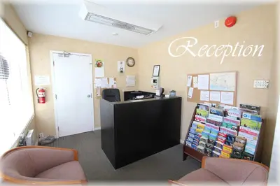 an office with a reception desk and two chairs at Lotus Motel in Cobourg