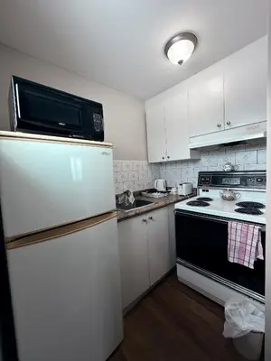 a kitchen with a refrigerator and a microwave at Guest Inn Motel in Trenton