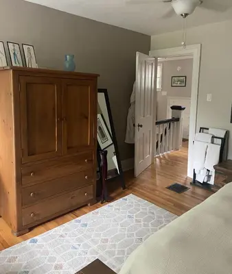 a bedroom with a bed and a dresser and a staircase at Cottage on Caledonia Bed & Breakfast in Stratford