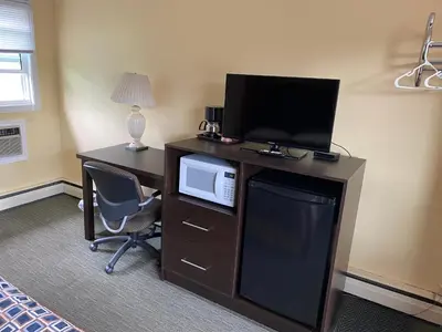 a room with a desk with a television and a computer at All Seasons Motel in Port Elgin