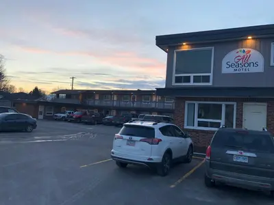 a car parked in a parking lot in front of a store at All Seasons Motel in Port Elgin