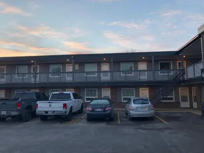 a building with cars parked in a parking lot at All Seasons Motel in Port Elgin