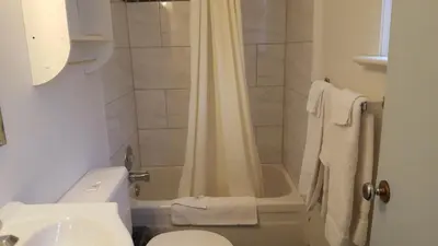 a bathroom with a shower and a toilet and a sink at All Seasons Motel in Port Elgin