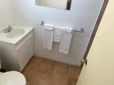a bathroom with a sink and a toilet and towels at All Seasons Motel in Port Elgin